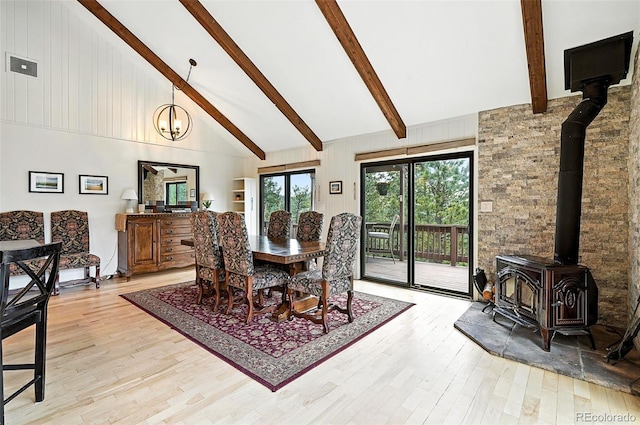 7221 S Brook Forest Rd, Evergreen, CO 80439 - dining room with a wood stove, high vaulted ceiling, beam ceiling, and light wood-style floors