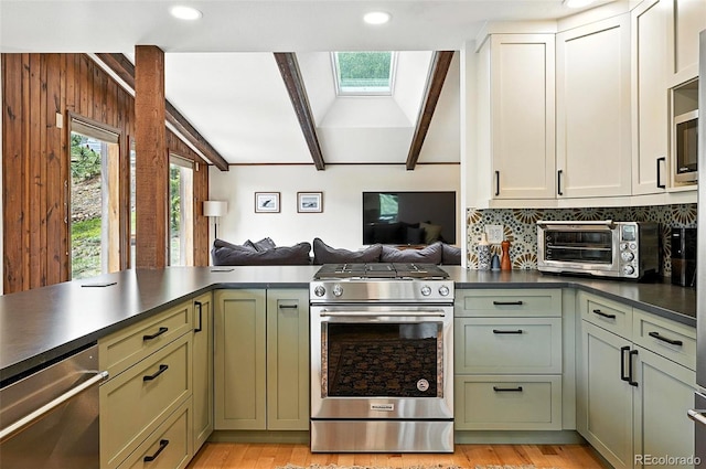 7221 S Brook Forest Rd, Evergreen, CO 80439 - kitchen with stainless steel appliances, green cabinets, dark countertops, open floor plan, and recessed lighting