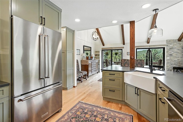 7221 S Brook Forest Rd, Evergreen, CO 80439 - kitchen with appliances with stainless steel finishes, dark countertops, light wood-type flooring, and hanging light fixtures