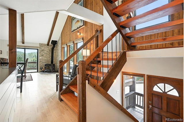 7221 S Brook Forest Rd, Evergreen, CO 80439 - stairs with a wood stove, high vaulted ceiling, hardwood / wood-style floors, and beamed ceiling