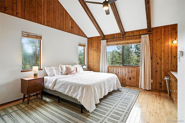 7221 S Brook Forest Rd, Evergreen, CO 80439 - bedroom featuring light wood-type flooring, wooden walls, high vaulted ceiling, beamed ceiling, and a ceiling fan