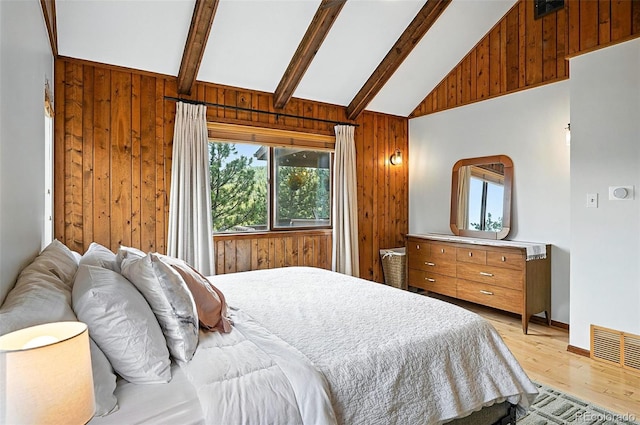 7221 S Brook Forest Rd, Evergreen, CO 80439 - bedroom featuring wooden walls, beamed ceiling, light wood-style flooring, and high vaulted ceiling