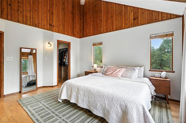 7221 S Brook Forest Rd, Evergreen, CO 80439 - bedroom featuring multiple windows, a walk in closet, a closet, light wood finished floors, and vaulted ceiling