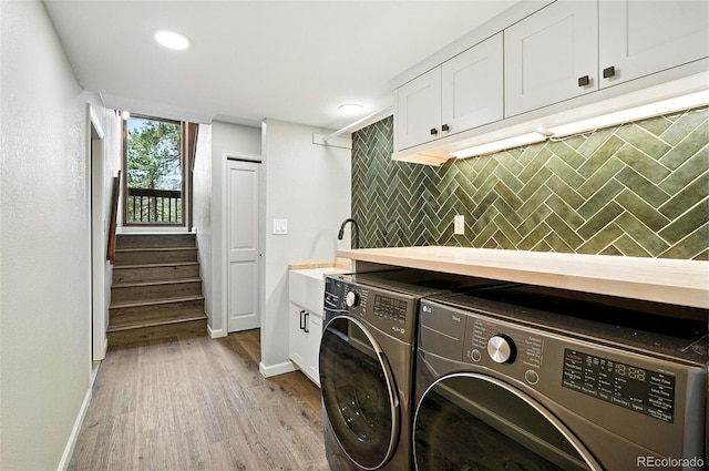 7221 S Brook Forest Rd, Evergreen, CO 80439 - laundry room with washer and dryer, light wood-style flooring, cabinet space, and recessed lighting