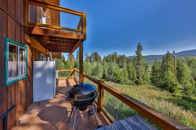 wooden deck featuring a mountain view and grilling area