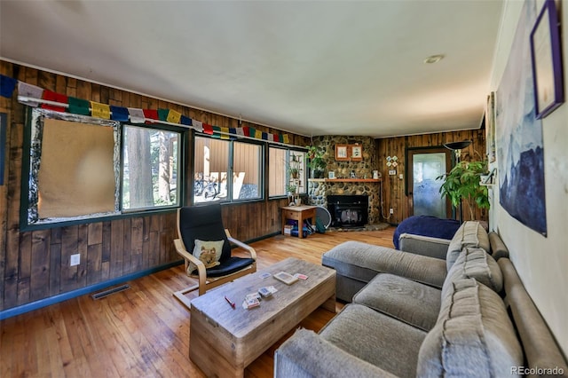 living room featuring wood walls, hardwood / wood-style floors, and a fireplace