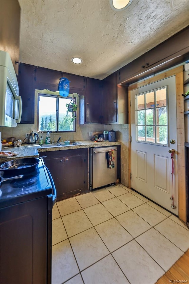 kitchen featuring a textured ceiling, light tile patterned floors, backsplash, stainless steel dishwasher, and electric range