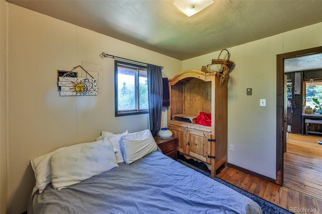 bedroom with a textured ceiling and hardwood / wood-style floors