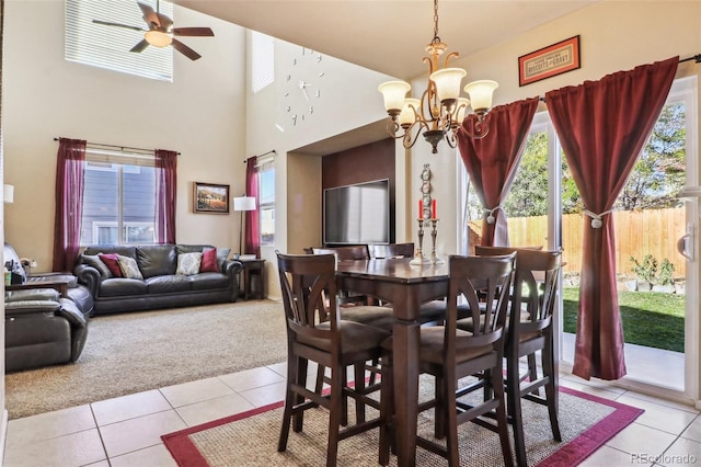 14389 E 101st Pl, Commerce City, CO 80022 - dining room with light tile patterned floors, light carpet, a chandelier, a ceiling fan, and a high ceiling