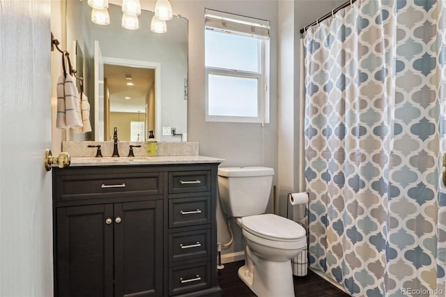 14389 E 101st Pl, Commerce City, CO 80022 - bathroom featuring toilet, vanity, wood finished floors, and a shower with curtain