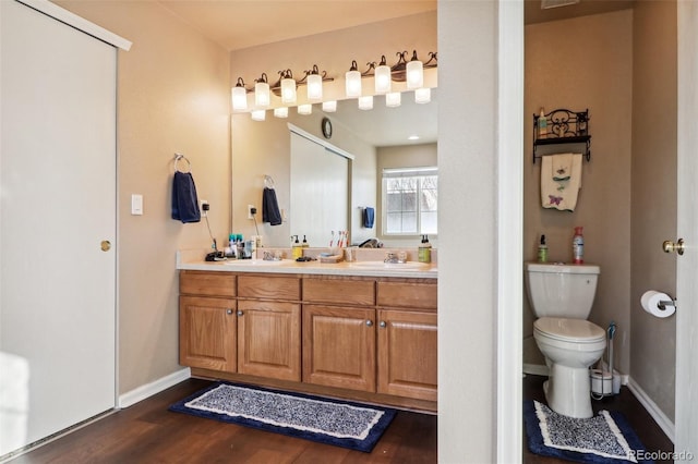 14389 E 101st Pl, Commerce City, CO 80022 - full bath featuring double vanity, wood finished floors, toilet, and baseboards
