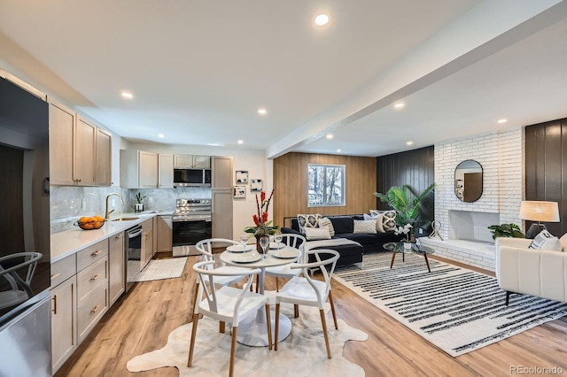 1040 Grove St, Denver, CO 80204 - kitchen featuring light wood finished floors, open floor plan, a sink, and appliances with stainless steel finishes