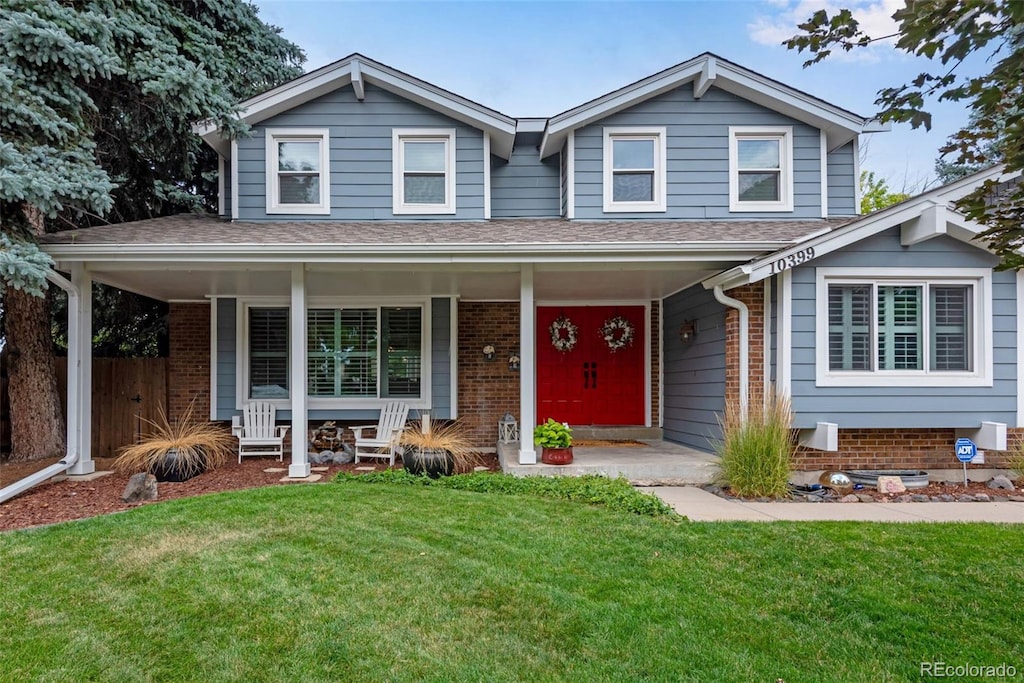 view of front of house with covered porch and a front lawn