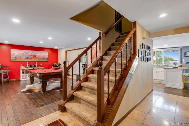 stairs with pool table and hardwood / wood-style flooring