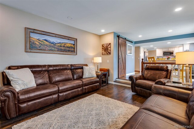 living room featuring dark hardwood / wood-style flooring and a barn door