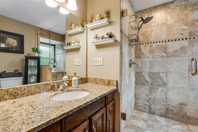 bathroom with walk in shower, vanity, and toilet