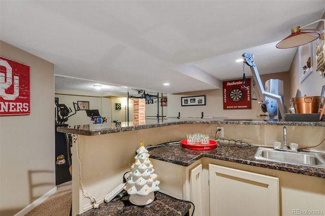 kitchen featuring carpet, dark stone countertops, and sink