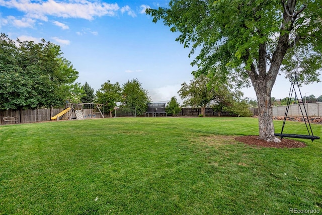 view of yard featuring a playground and a trampoline