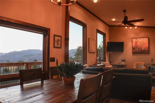 living room featuring a mountain view, ornamental molding, ceiling fan with notable chandelier, and hardwood / wood-style flooring