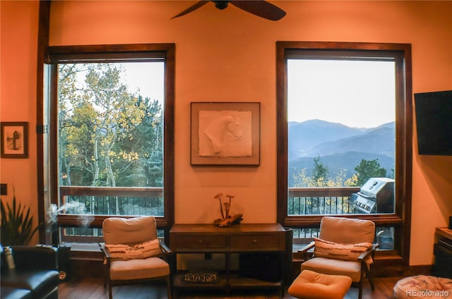 living area featuring hardwood / wood-style floors and ceiling fan