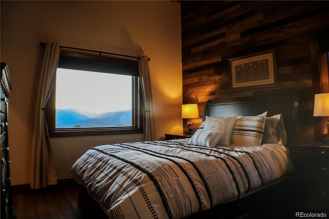 bedroom with wood walls and dark wood-type flooring