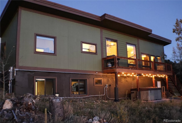 rear view of house featuring a hot tub