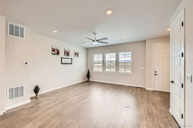spare room with light wood finished floors, visible vents, baseboards, and a ceiling fan