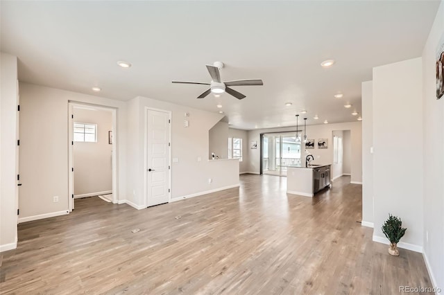 unfurnished living room featuring a sink, light wood-style flooring, a ceiling fan, and recessed lighting