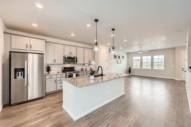 kitchen with a sink, appliances with stainless steel finishes, recessed lighting, a ceiling fan, and light wood-style floors