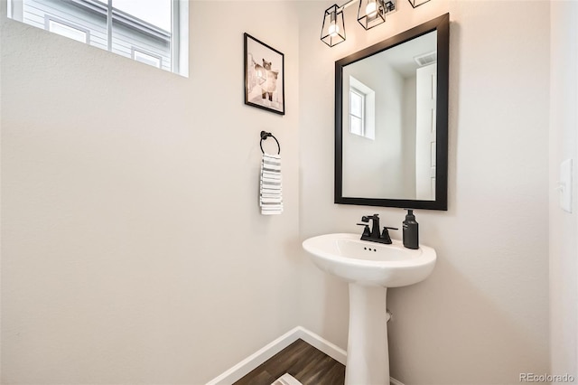 bathroom featuring wood finished floors, baseboards, and a sink