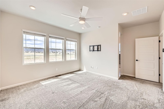 carpeted empty room with visible vents, baseboards, a ceiling fan, and recessed lighting