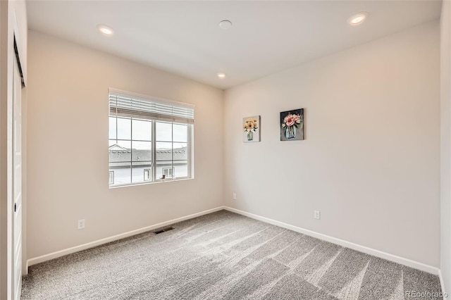 carpeted empty room with visible vents, baseboards, and recessed lighting