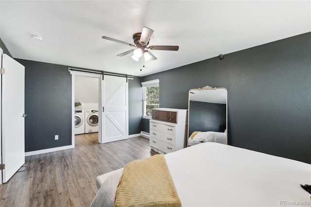 11390 Shimley Rd, Golden, CO 80403 - bedroom with independent washer and dryer, a barn door, baseboards, and wood finished floors