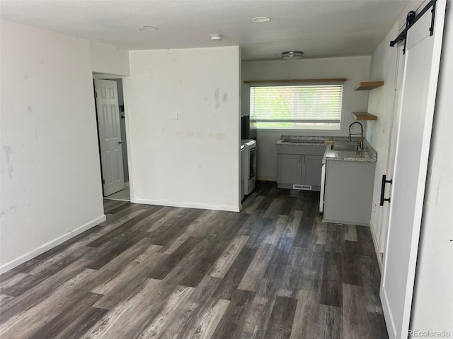 2815 S Dexter Way, Denver, CO 80222 - kitchen featuring open shelves, a barn door, a sink, dark wood finished floors, and light countertops