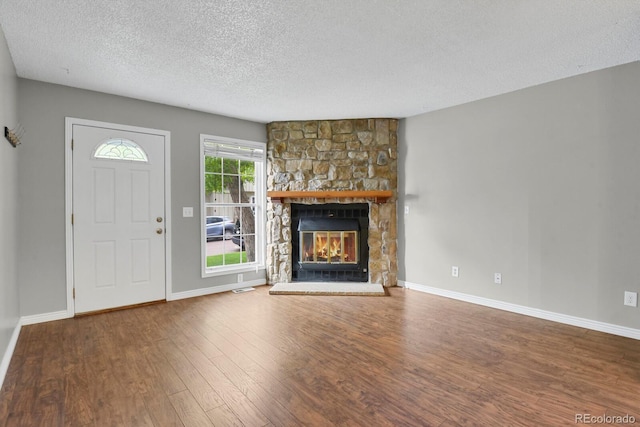 3619 Queen Anne Way, Colorado Springs, CO 80917 - unfurnished living room with a textured ceiling, wood finished floors, a fireplace, and baseboards
