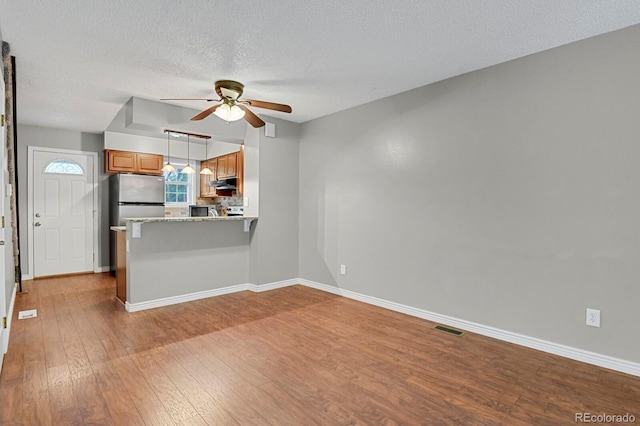 3619 Queen Anne Way, Colorado Springs, CO 80917 - unfurnished living room with ceiling fan, wood finished floors, a textured ceiling, and baseboards