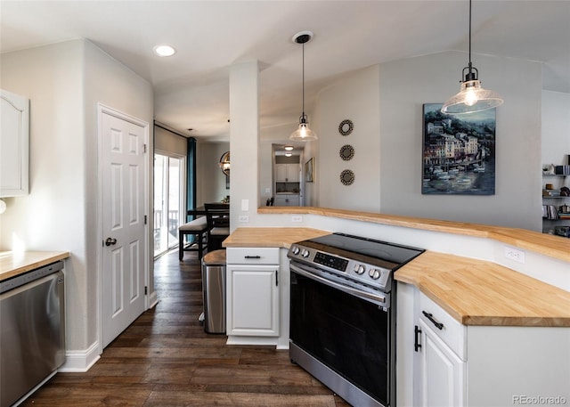 kitchen with stainless steel appliances, hanging light fixtures, white cabinets, and butcher block countertops