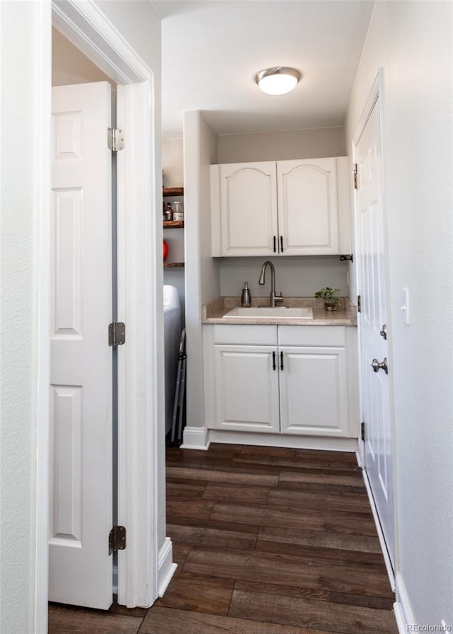 interior space featuring sink, dark wood-type flooring, and white cabinets