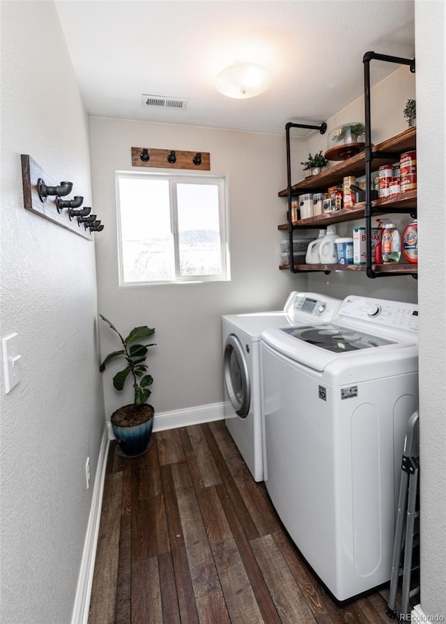 laundry room with dark hardwood / wood-style flooring and washing machine and dryer