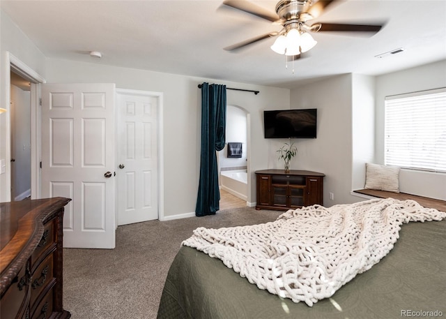 carpeted bedroom featuring a closet, ceiling fan, and ensuite bathroom