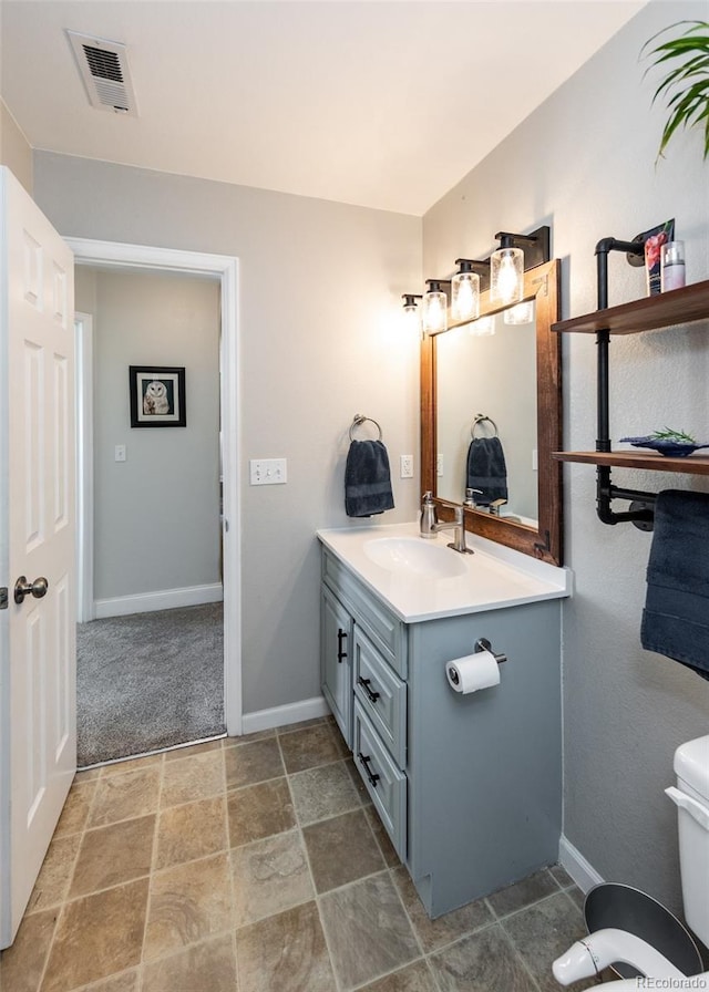 bathroom featuring vanity and toilet