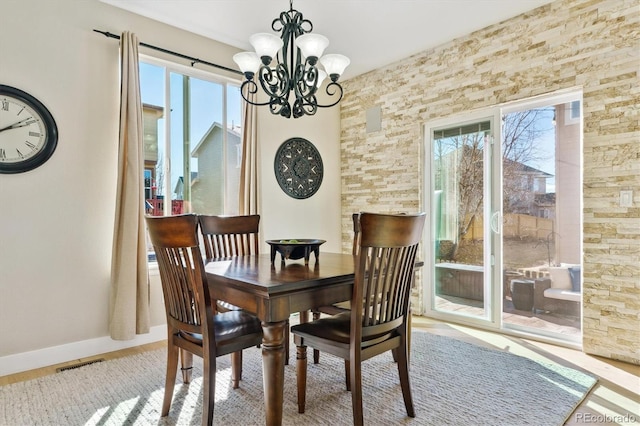 dining room featuring a wealth of natural light and a notable chandelier