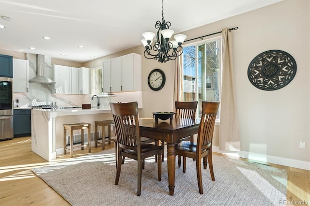 dining space with a healthy amount of sunlight, sink, and light hardwood / wood-style floors