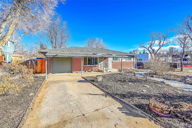 ranch-style home featuring a garage, concrete driveway, brick siding, and fence