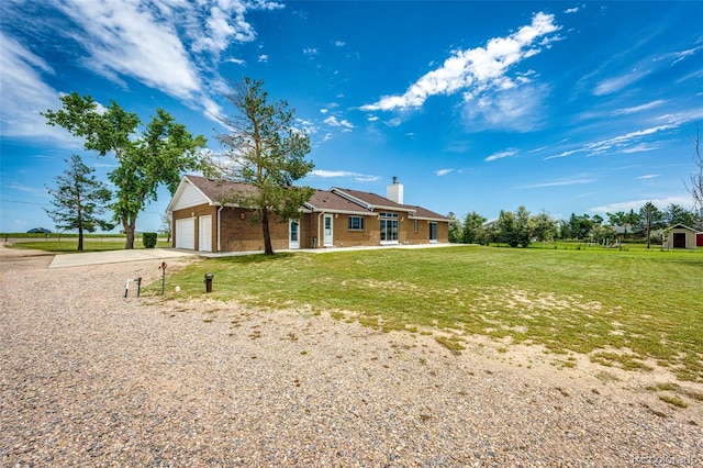 41020 US Highway 36, Bennett, CO 80102 - view of front of property featuring concrete driveway, a front lawn, a garage, a chimney, and brick siding