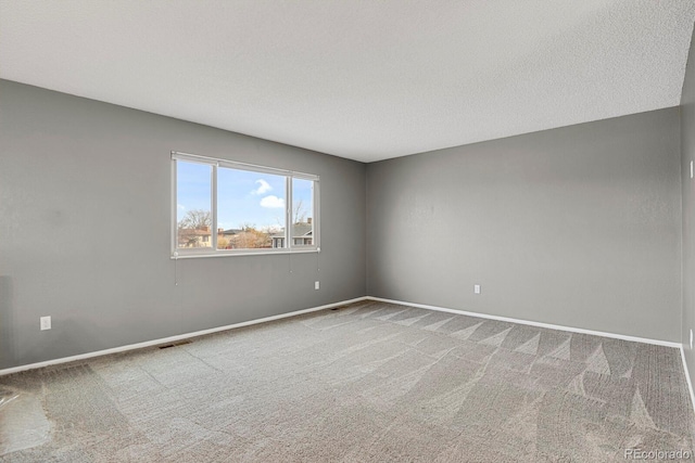 carpeted empty room featuring a textured ceiling