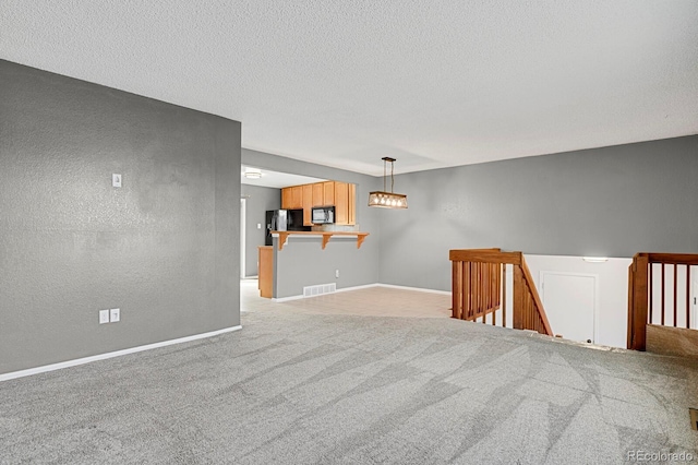 unfurnished room featuring light colored carpet and a textured ceiling