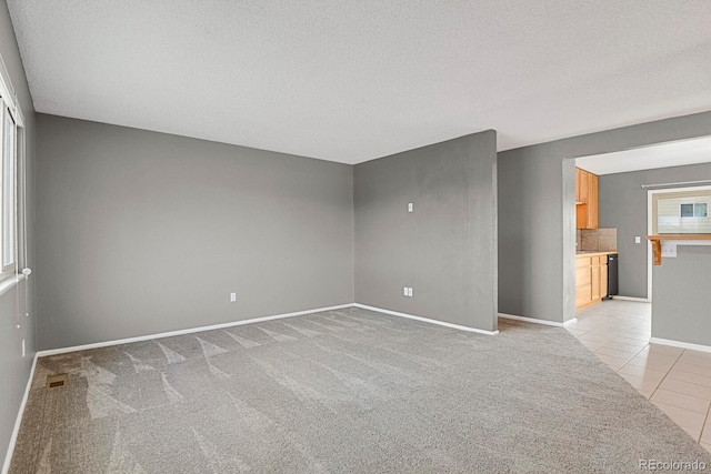 empty room with light tile patterned floors and a textured ceiling