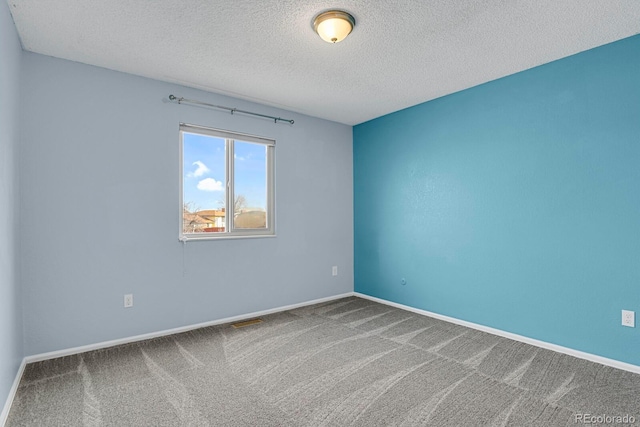 spare room featuring carpet and a textured ceiling