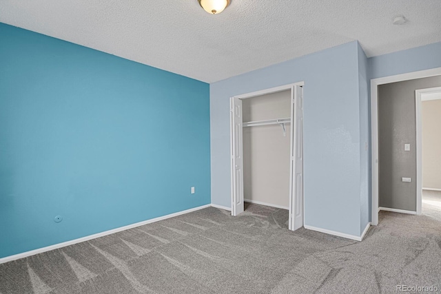 unfurnished bedroom with carpet floors, a textured ceiling, and a closet